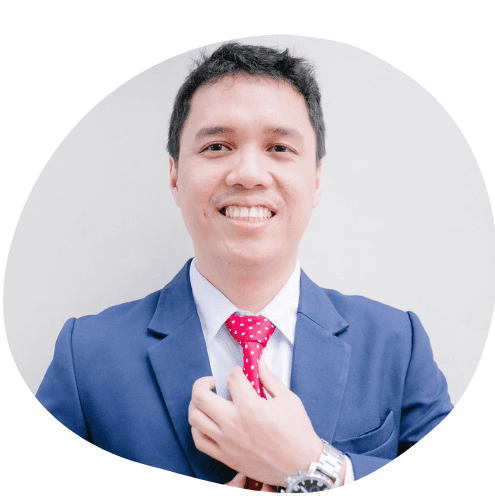 Zyrus Valiente smiling in a blue suit and red tie